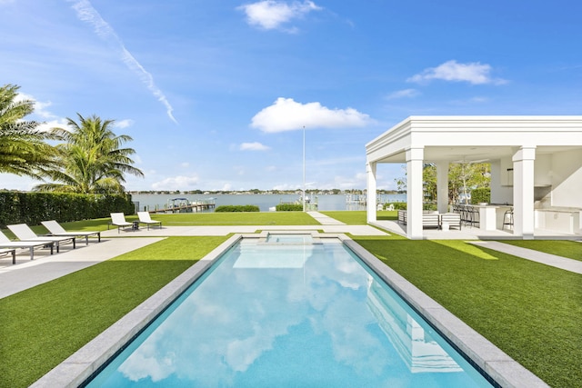 view of swimming pool featuring a yard, area for grilling, a water view, a patio, and a bar