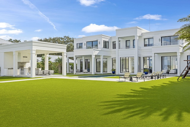 back of house featuring a yard and a balcony