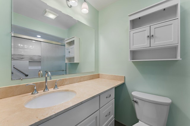 bathroom with an enclosed shower, vanity, and toilet