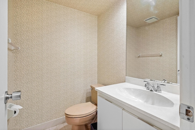 bathroom featuring tile patterned flooring, vanity, and toilet