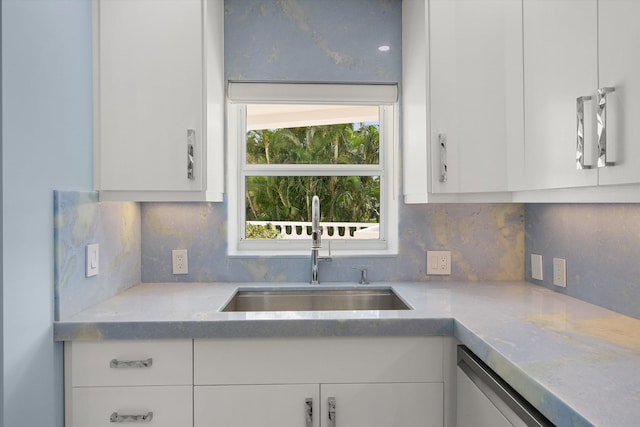 kitchen featuring white cabinets, tasteful backsplash, dishwasher, and sink