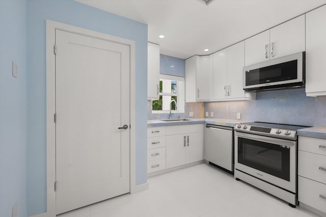 kitchen with white cabinets, backsplash, sink, and appliances with stainless steel finishes