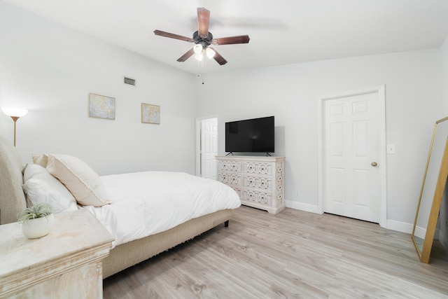 bedroom with ceiling fan, light hardwood / wood-style floors, and vaulted ceiling