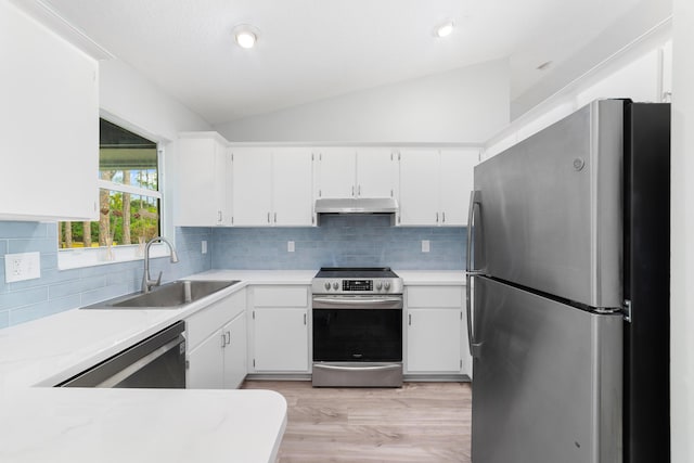 kitchen featuring sink, white cabinets, stainless steel appliances, and vaulted ceiling