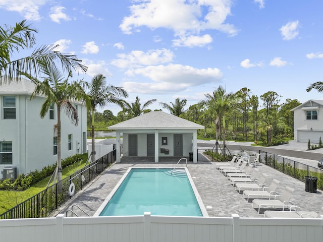 view of swimming pool with central air condition unit and a patio area