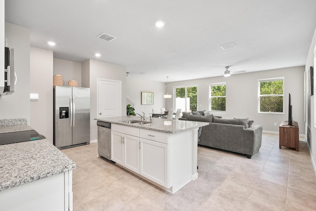 kitchen featuring appliances with stainless steel finishes, ceiling fan, a kitchen island with sink, sink, and white cabinetry