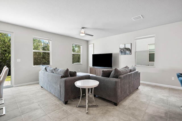 tiled living room featuring a textured ceiling and ceiling fan