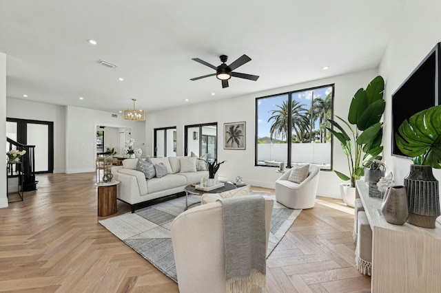 living room featuring ceiling fan with notable chandelier and light parquet floors