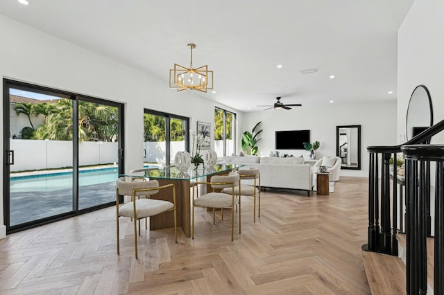 dining space featuring light parquet flooring and ceiling fan with notable chandelier