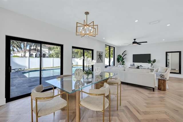 dining space with ceiling fan with notable chandelier and light parquet flooring