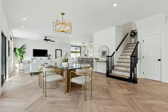 dining area featuring light parquet floors and ceiling fan with notable chandelier