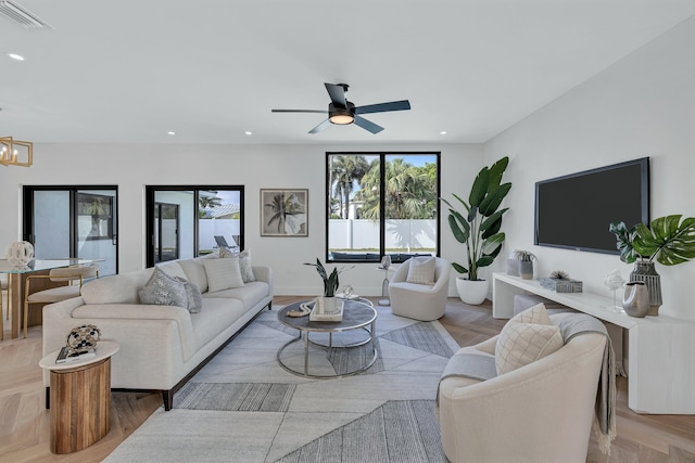 living room with ceiling fan with notable chandelier