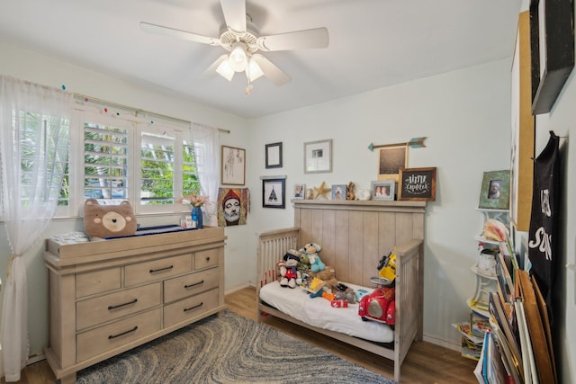 bedroom with dark hardwood / wood-style flooring and ceiling fan