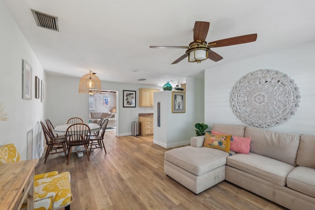 living room featuring ceiling fan and light hardwood / wood-style flooring