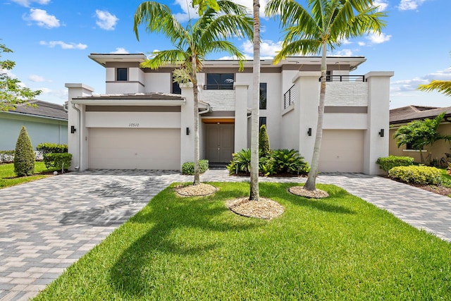 view of front of property with a garage, a balcony, and a front lawn