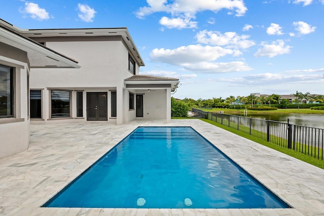 view of swimming pool with a water view and a patio area