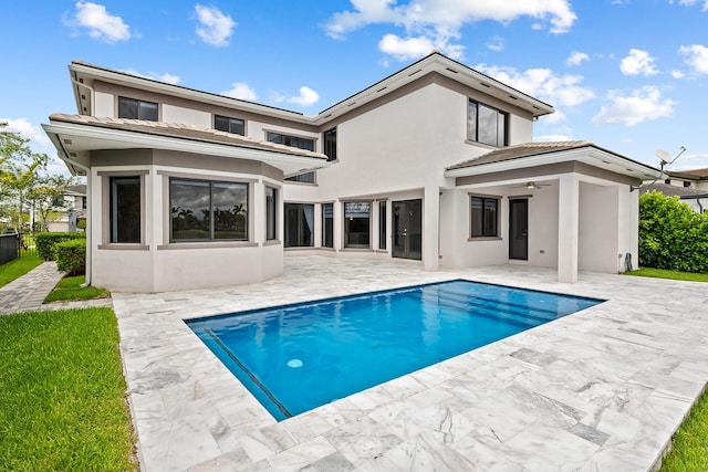 back of property with ceiling fan and a patio