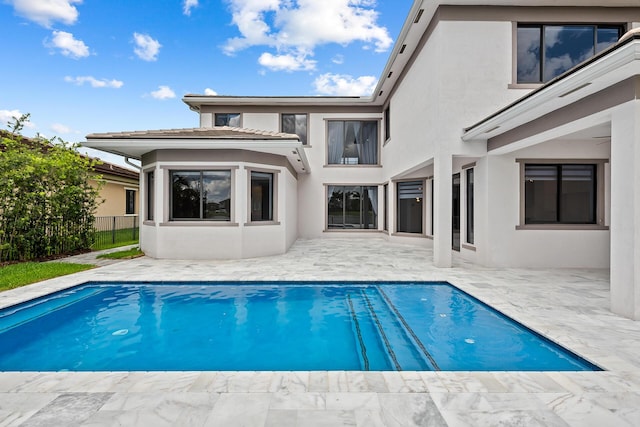 back of house with a fenced in pool