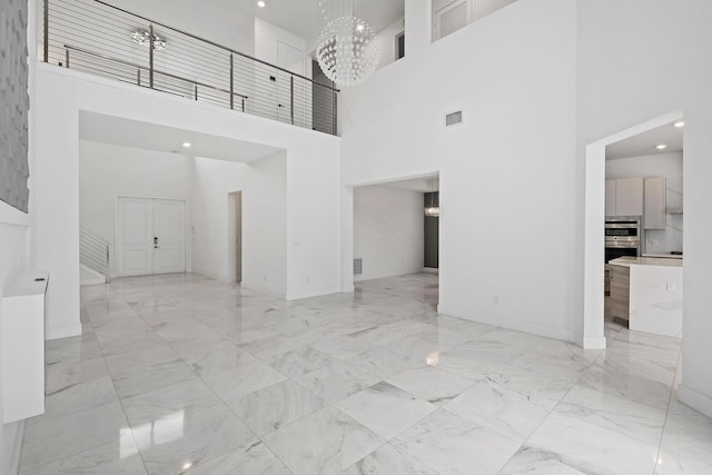 interior space with a towering ceiling and an inviting chandelier