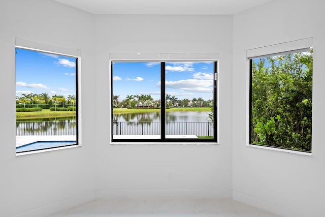 spare room featuring a wealth of natural light and a water view