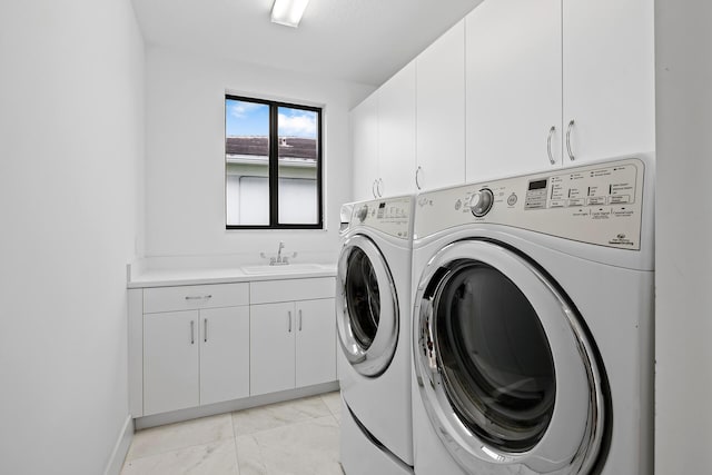 washroom with washer and dryer, cabinets, and sink