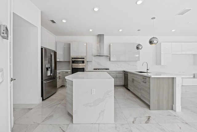 kitchen with wall chimney exhaust hood, stainless steel appliances, sink, pendant lighting, and white cabinetry