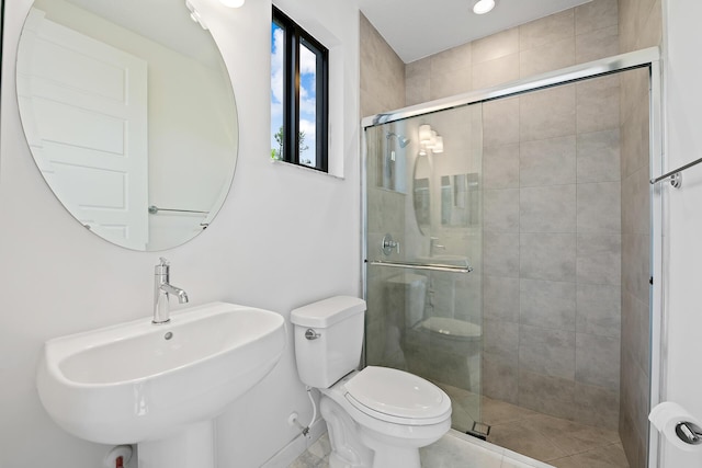 bathroom with tile patterned flooring, toilet, a shower with door, and sink