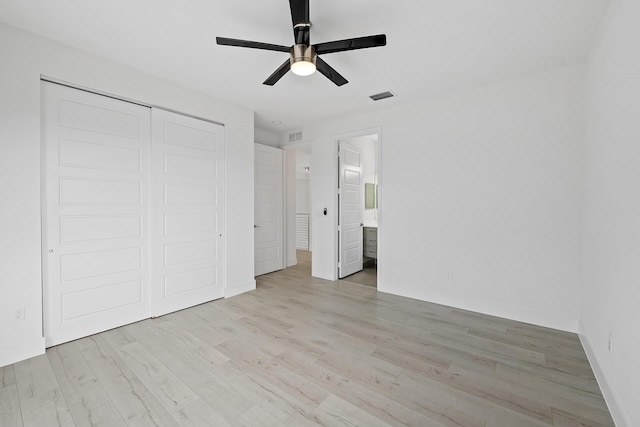 unfurnished bedroom with a closet, ceiling fan, light hardwood / wood-style floors, and ensuite bathroom