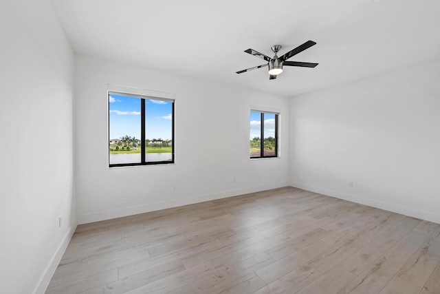 unfurnished room with ceiling fan, a wealth of natural light, and light hardwood / wood-style flooring