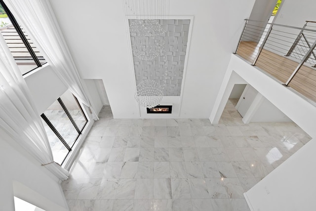 unfurnished living room with a large fireplace and a towering ceiling