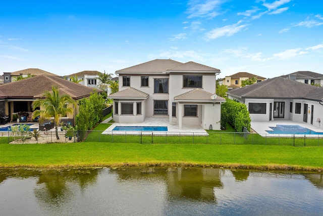 rear view of house with a water view, a fenced in pool, a patio area, and a lawn