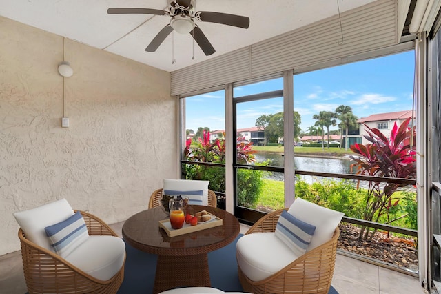 sunroom / solarium featuring a water view and ceiling fan