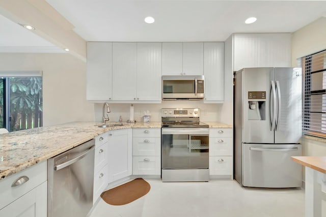 kitchen with white cabinetry, sink, light stone counters, and stainless steel appliances