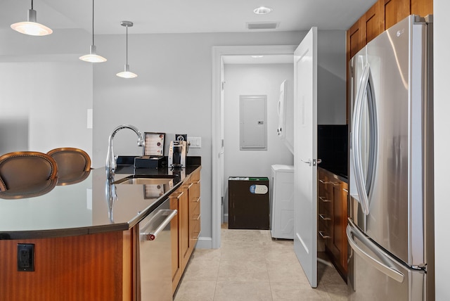 kitchen with sink, hanging light fixtures, stainless steel appliances, electric panel, and light tile patterned floors