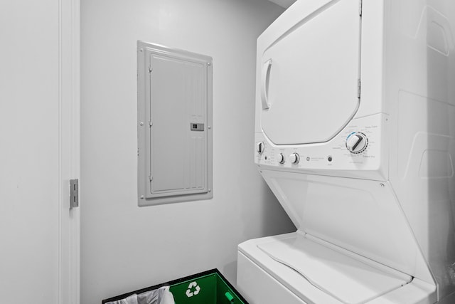 washroom with electric panel and stacked washer and clothes dryer