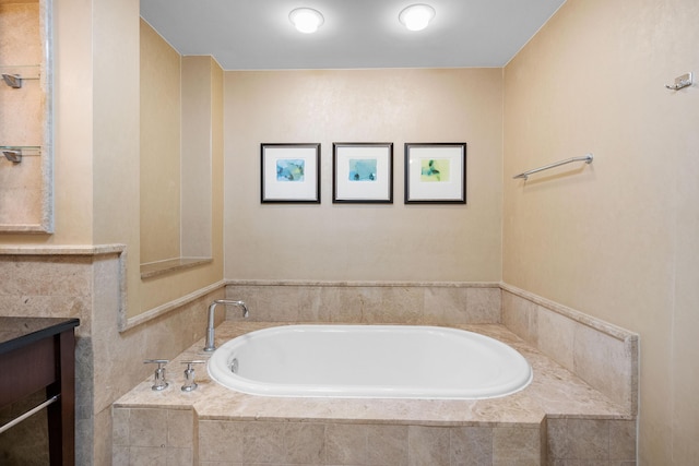 bathroom with vanity and tiled bath