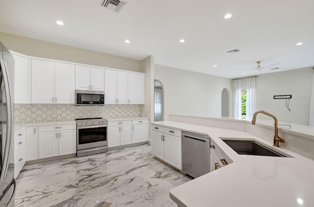 kitchen featuring white cabinets, appliances with stainless steel finishes, and sink