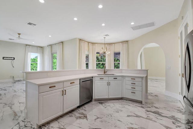 kitchen with ceiling fan with notable chandelier, stainless steel appliances, white cabinetry, and sink