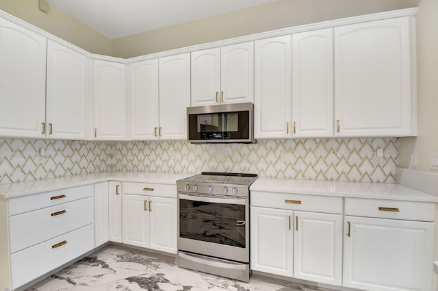 kitchen with white cabinetry, stainless steel appliances, and tasteful backsplash