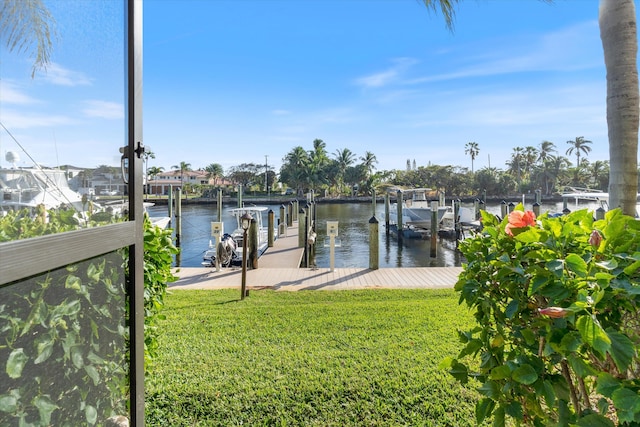 view of dock with a water view and a yard