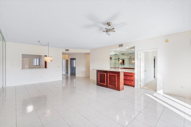 unfurnished living room featuring ceiling fan with notable chandelier, light tile patterned floors, and a textured ceiling