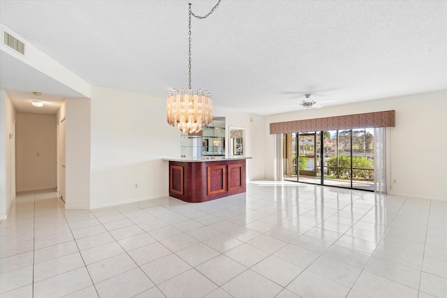 tiled spare room featuring a textured ceiling and ceiling fan with notable chandelier