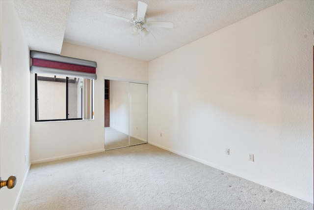 empty room with ceiling fan, light carpet, and a textured ceiling