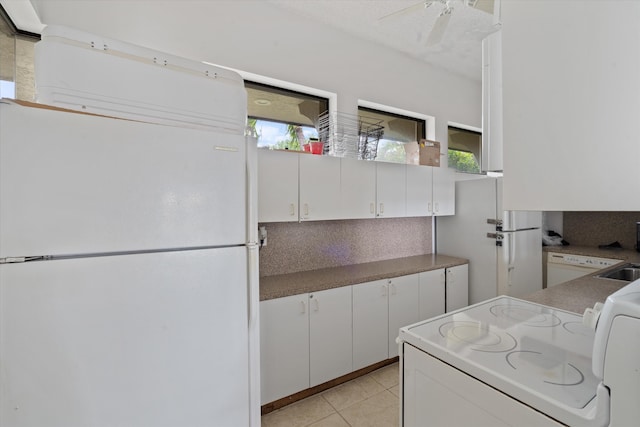 kitchen with white appliances, white cabinetry, ceiling fan, and light tile patterned flooring