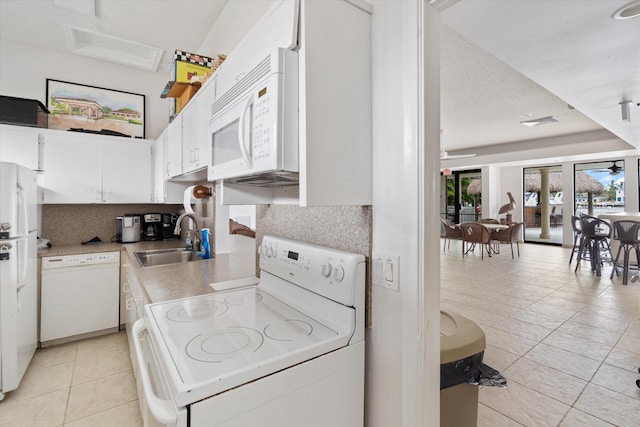 kitchen with white cabinets, white appliances, tasteful backsplash, and sink