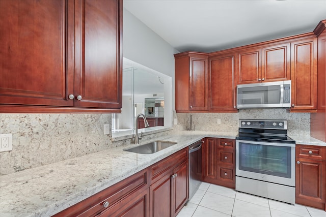 kitchen with light stone countertops, sink, stainless steel appliances, backsplash, and light tile patterned flooring