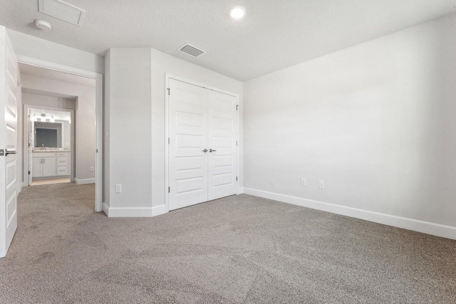 unfurnished bedroom with a closet, carpet, and a textured ceiling