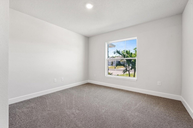 carpeted empty room featuring a textured ceiling