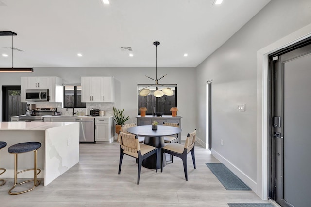 dining space with light hardwood / wood-style floors and sink