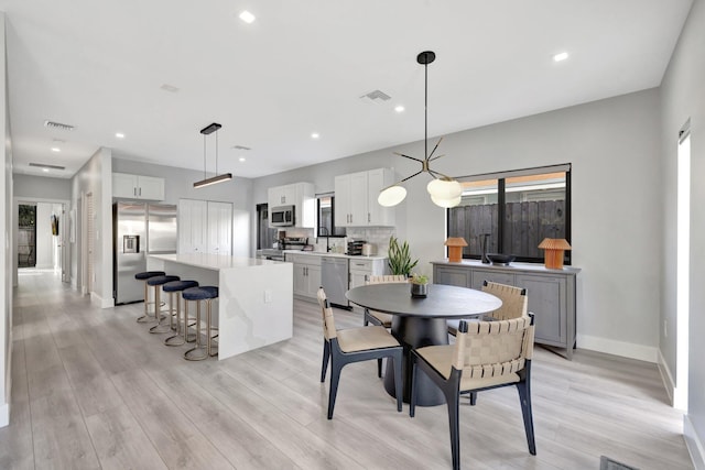 dining room featuring sink and light hardwood / wood-style floors